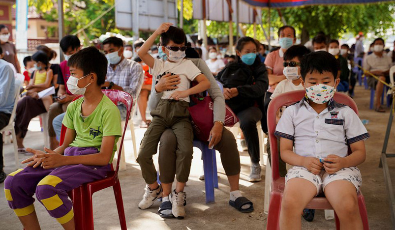 Children and their parents wait to receive a vaccine against the coronavirus disease